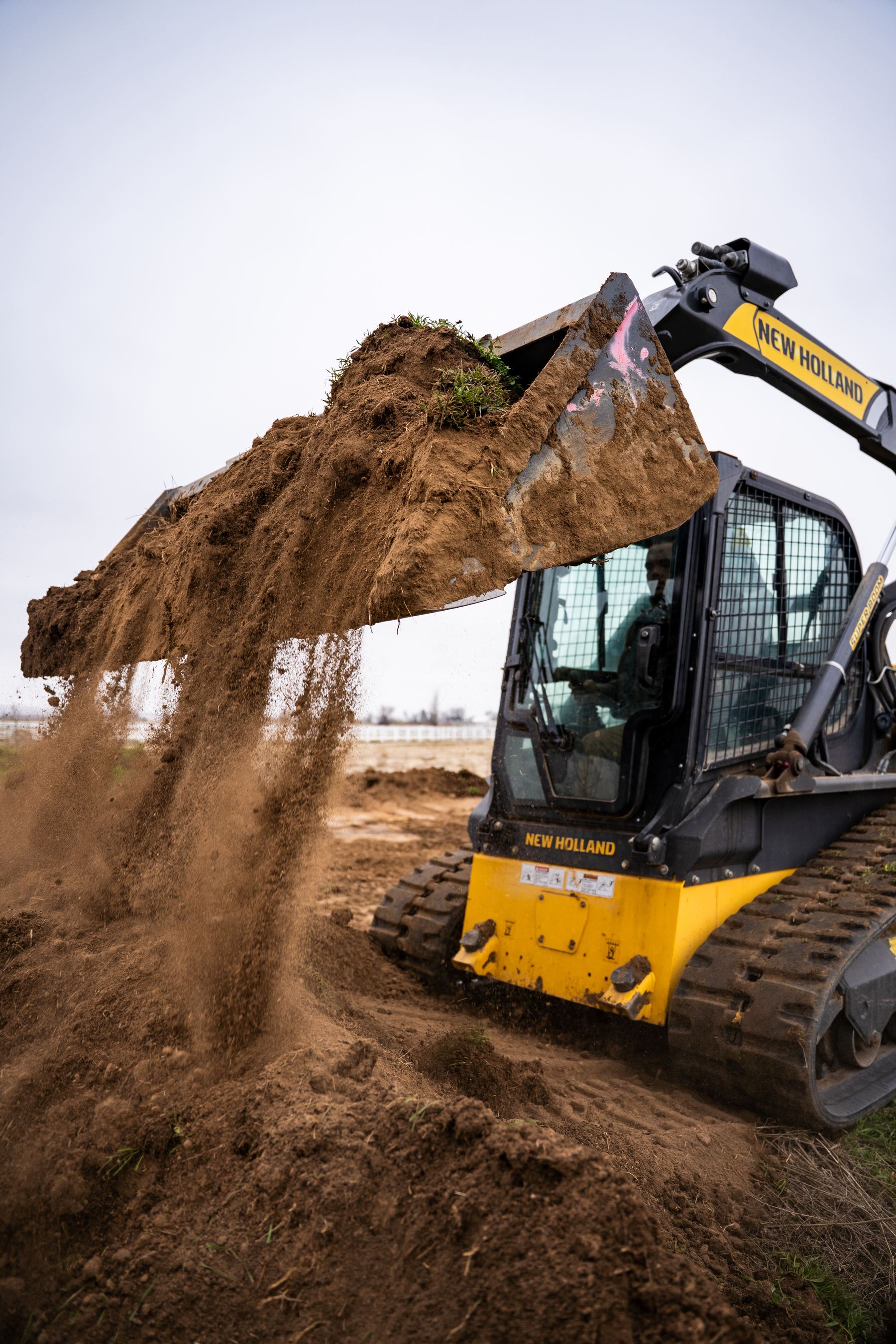 Close-up of a loader bucket full of soil and roots.